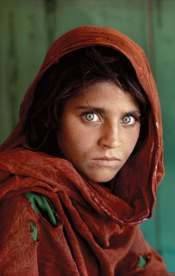 Afghan girl in a red hood with powerful green eyes, photographed by Steve My Curry