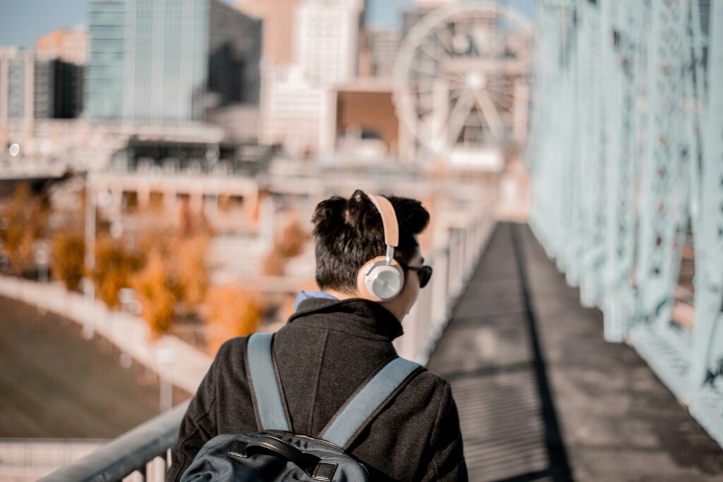Person wearing headphones while strolling, capturing the intimate connection between podcasts and art appreciation.