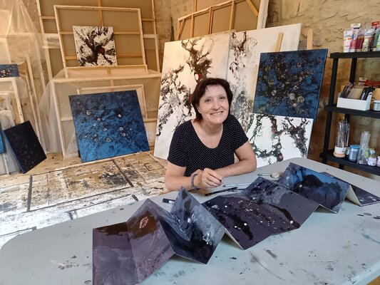 Odile CARITEAU en el estudio: Dans le petit atelier en 2021, avec un livre accordéon dans les tons bleus.