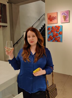 Jane Lantsman im Studio: At the exhibition "The salt of the earth. Food in Israeli Art", 2023, Bnei Brak. I'm syanding with two of my artworks (Pomegranates and Cherries) behind me.