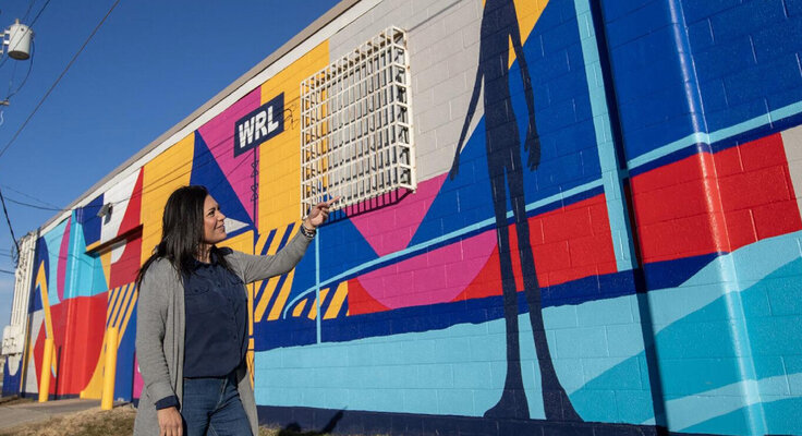 Ilaamen Pelshaw in the Studio: By my mural 'The Fabric of Council Bluffs' in Iowa