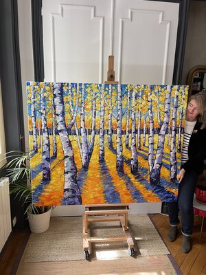 Mona Edulesco nello studio: Mona Edulesco in her studio standing next to a large commissioned oil painting created in 2024