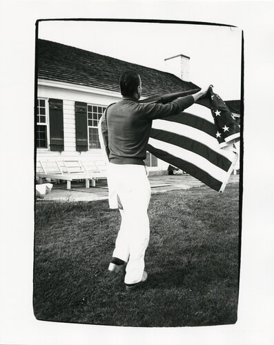 Halston Holding American Flag at Warhol's Montauk Estate di Andy Warhol, Fotografia in vendita su Singulart