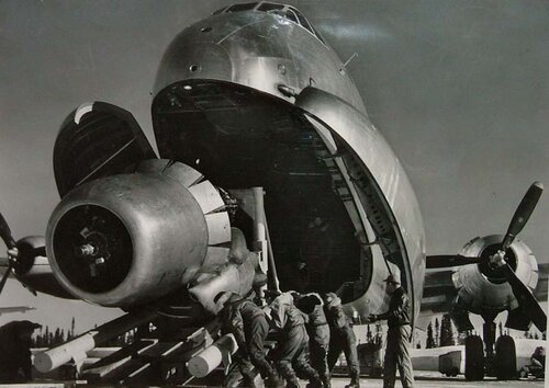 Crewmen Unloading Huge B-50 Bomber Plane Engine Used as a Spare from the Belly of a C-124 Cargo Plane upon Arrival at Strategic Air Command's Base, Greenland, TX par Margaret Bourke-White, Photographie en vente sur Singulart