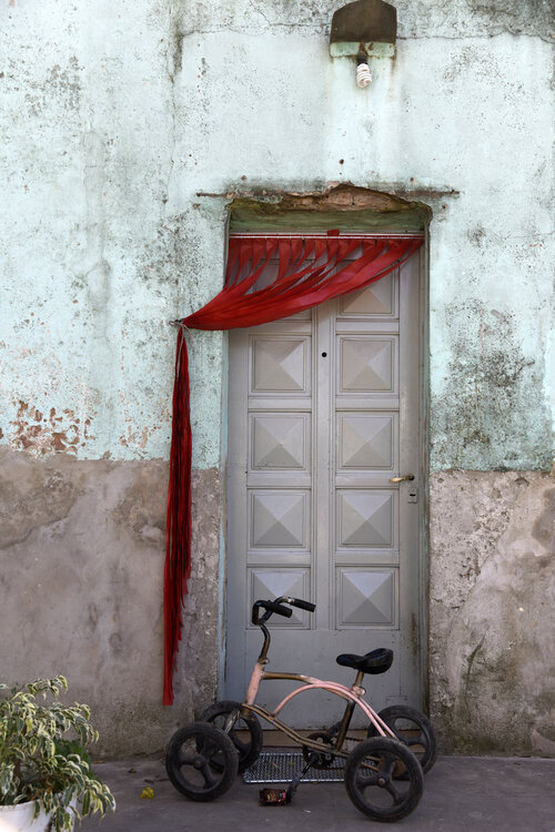 Tricycle and red curtain Silvina Batista