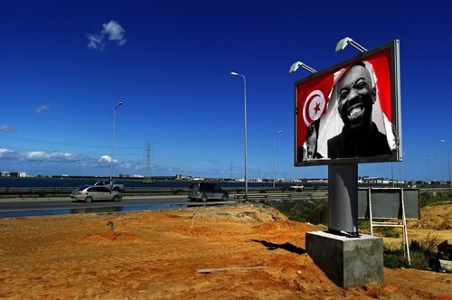 INSIDE OUT - Tunisia, Ex Ben Ali Billboard on La Goulette Road di JR, Fotografia in vendita su Singulart