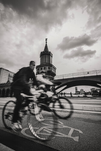 Cyclists on a gloomy day in Berlin with the Oberbaum tower in the background. by ihsan Okur, 사진 for Sale on Singulart