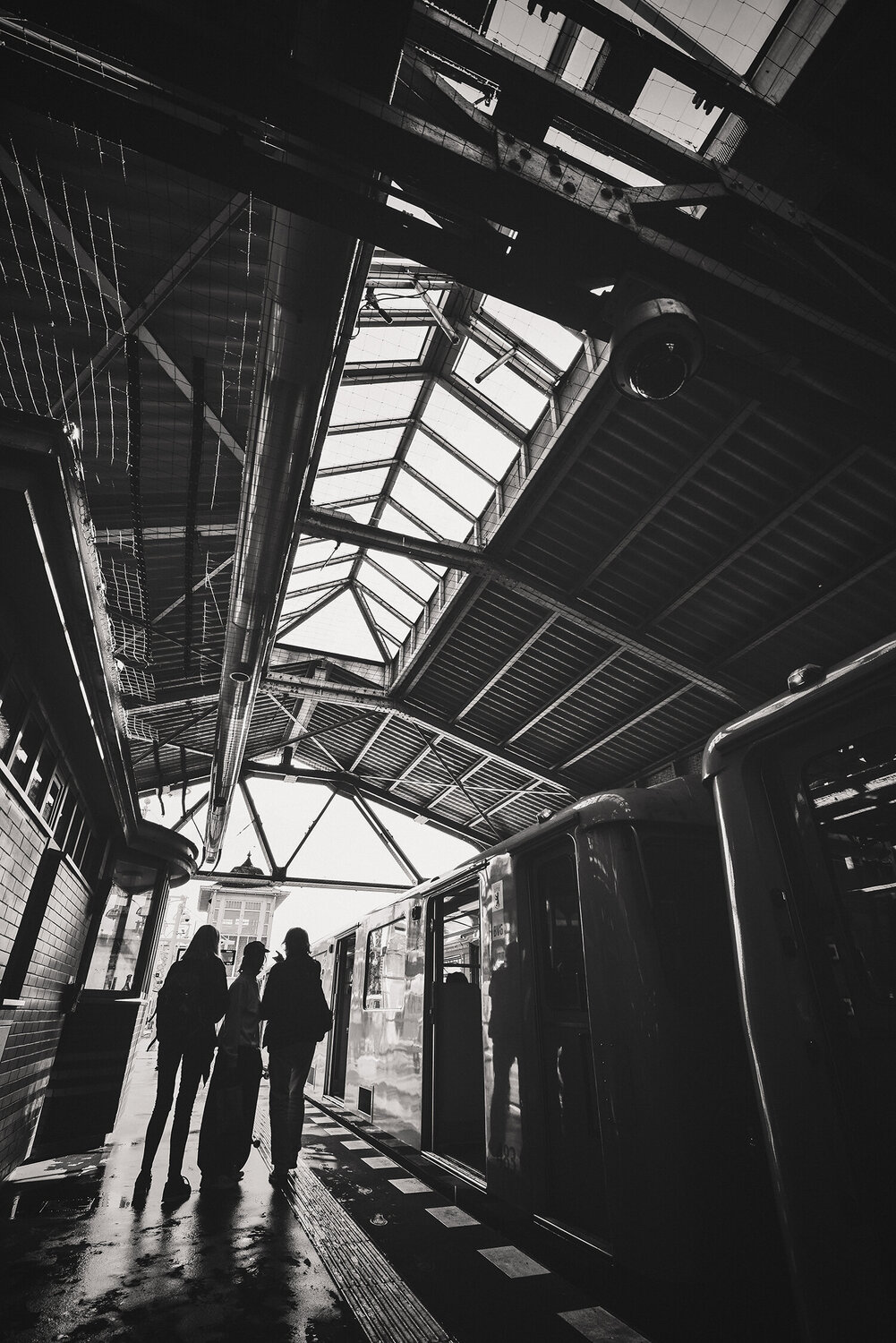People and architectural details at a train station in Berlin. ihsan Okur Fotografie zu verkaufen