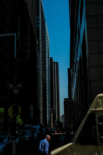 Man with bue shirt between Buildings by Chervine, Photography for Sale on Singulart