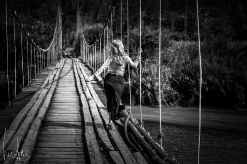 Fotografía Artística: Puente Colgante de Madera y Mujer en Blanco y Negro di Raul Martin, Fotografia in vendita su Singulart