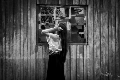 ¡¡Pieza exclusiva!! - Silueta femenina frente a ventana de madera rota y abandonada de Raul Martin, Fotografía a la venta en Singulart