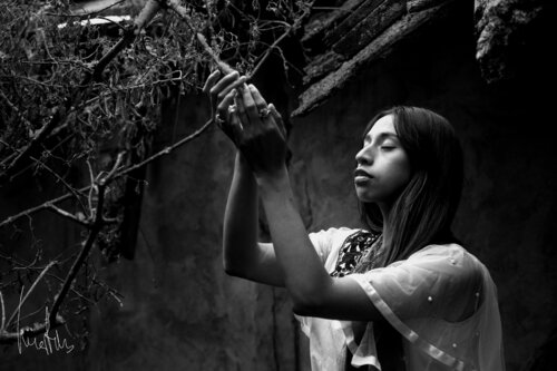 ¡¡Pieza exclusiva!! - Perfil de mujer indígena con ojos cerrados tocando ramas secas de Raul Martin, Fotografía a la venta en Singulart